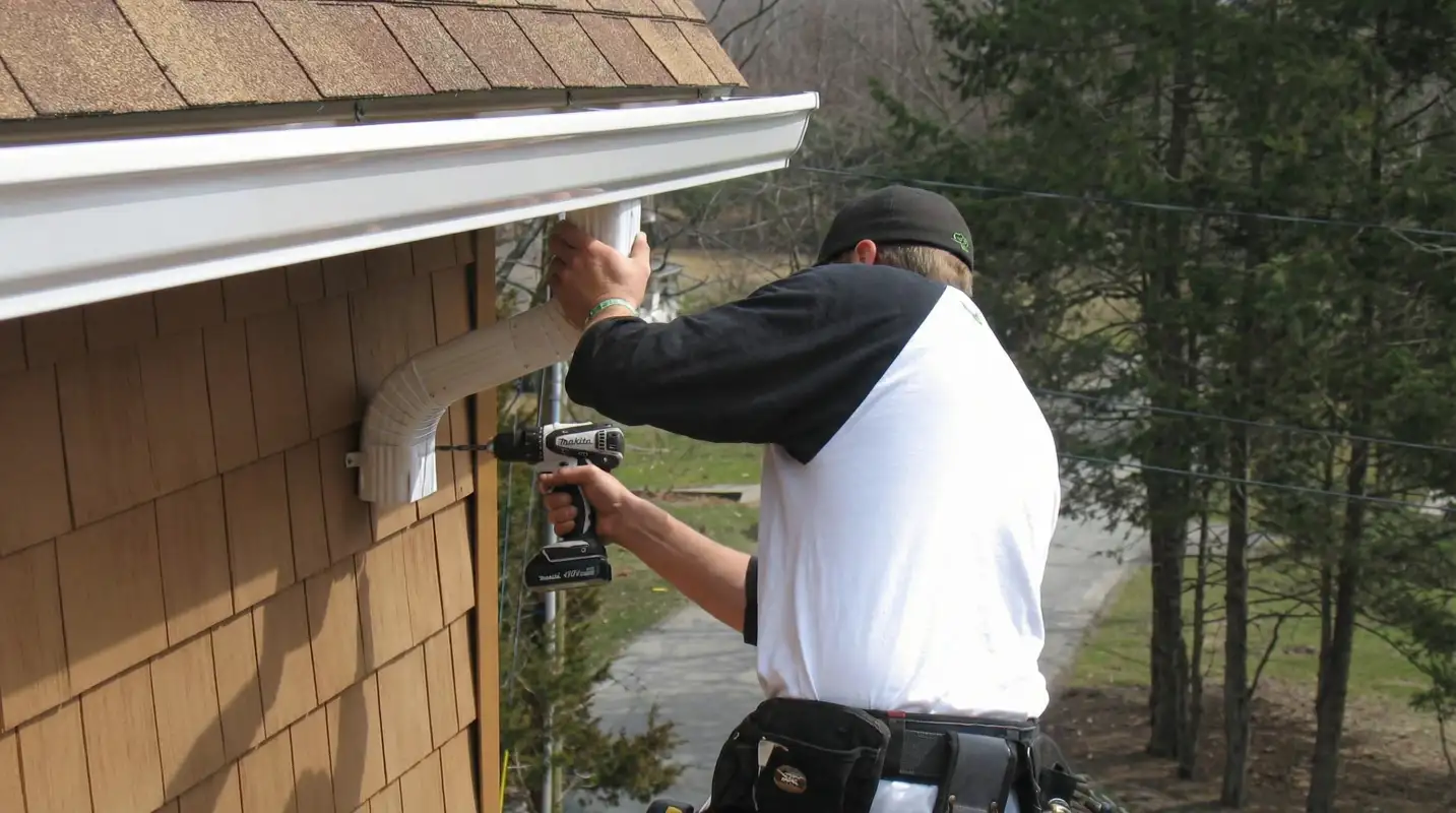 Professional contractor installing tan vinyl siding panels on a residential home exterior in Tampa, FL